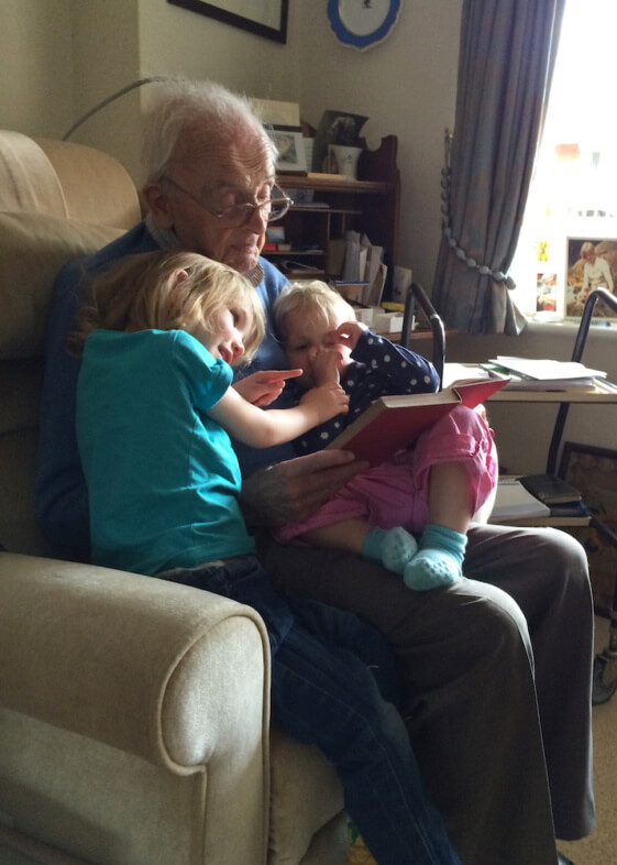 Grandfather reading to his Great Grandchildren