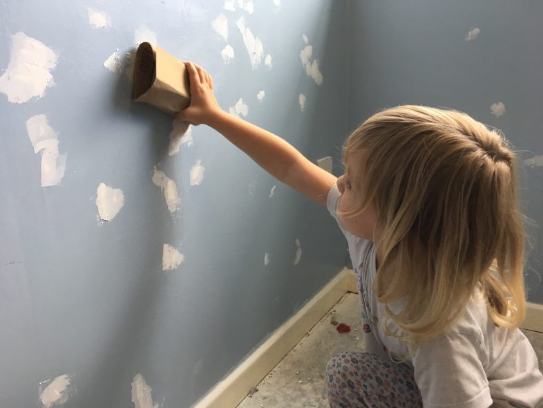 Lydia sanding the wall