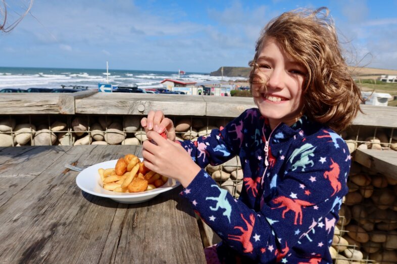 Georgie eating chicken and chips by the beach